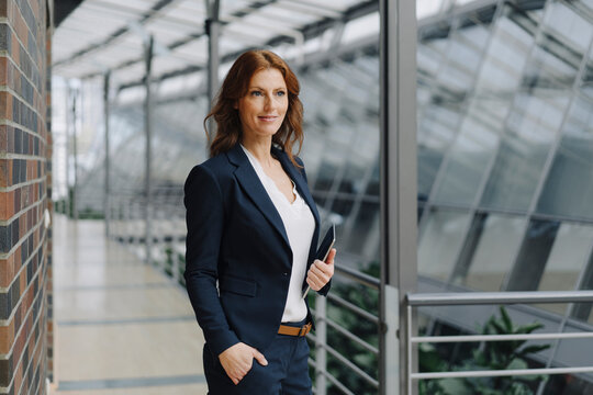 Confident businesswoman holding a tablet in a modern office building