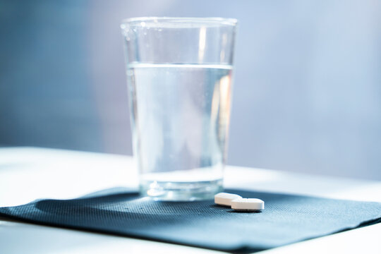Tablets and water glass on napkin