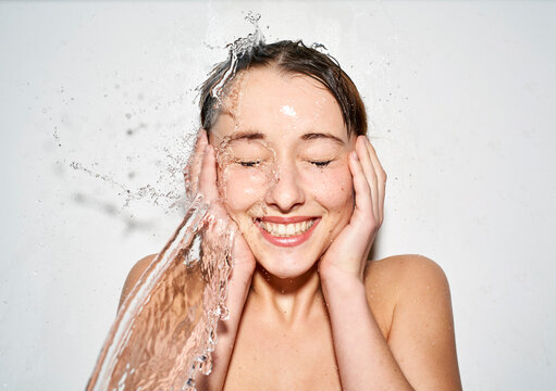 Portrait of laughing young woman with splashing water