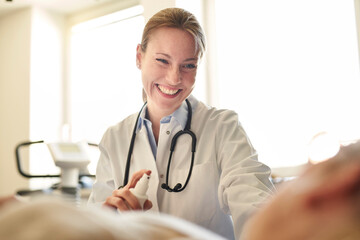 Smiling female doctor preparing a blood sampling from patient in medical practice