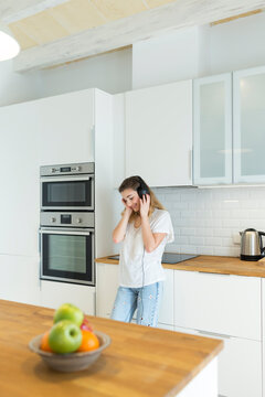 Female teeanger with headphones in the kitchen