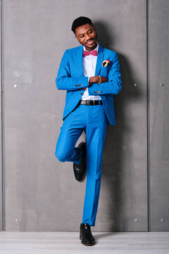 Smiling Man In Suit With Arms Crossed While Standing Against Wall