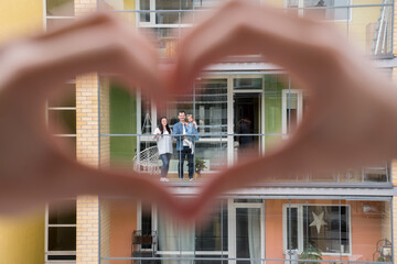 Woman's hands shaping heart with hands for her neighbours