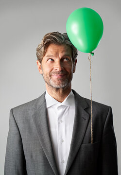 Portrait of smiling businessman with green balloon