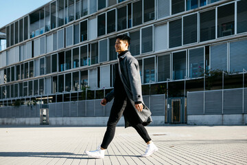 Spain, Barcelona, smiling young man walking down the street