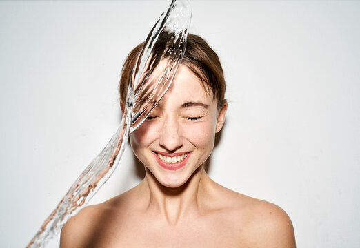 Portrait of laughing young woman with splashing water