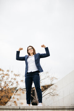 Confident businesswoman flexing muscles in the city
