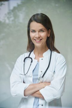 Portrait of smiling female doctor behind windowpane