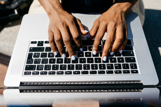 Businesswoman sitting on bench and using laptop finger typing
