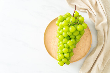 fresh green grape on wood plate