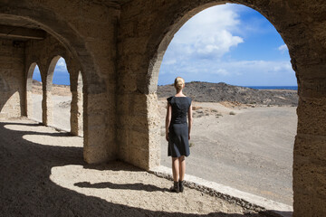Spain, Tenerife, Abades, Sanatorio de Abona, woman standing at arched window in ghost town building