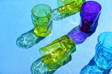 Beautiful empty glasses on blue background