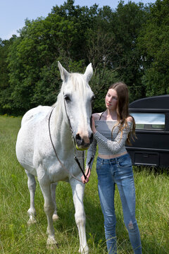 Portrait of teeange girl with horse on a meadow