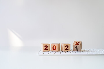 wood blocks cubes with a number 2021 change to 2022 on keyboard. new year 2021- 2022 concept.