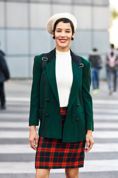 Portrait of smiling fashionable young woman on zebra crossing