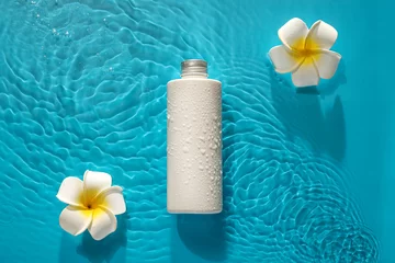 Tuinposter Bottle of cosmetic product and plumeria flowers in water on color background © Pixel-Shot