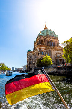 Germany, Berlin, Berlin Cathedral and German flag on excursion boat on River Spree