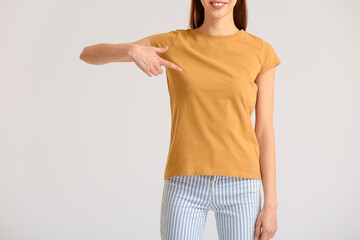 Young woman in modern t-shirt on light background