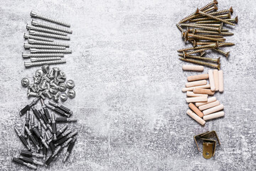 Different bolts, screws, dowels and furniture corners on grey background