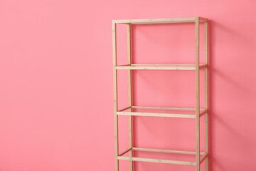 Stylish wooden shelf unit on color background