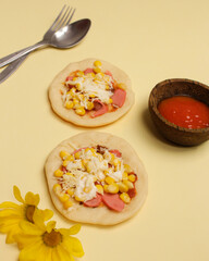 Mini pizza with corn, sausage and cheese topping for your lunch menu. pizza is a savory dish from Italy a kind of round and flat dough, baked in the oven. Pizza mockups. Focus blur. Focus on some ange