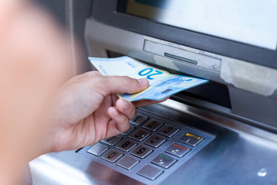 Close up of businesswoman withdraw money on a cash machine