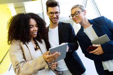 Smiling young business people sharing a tablet