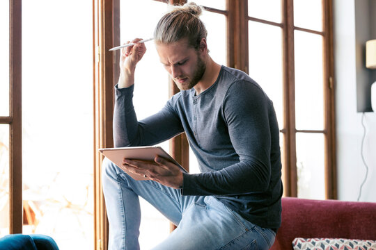 Young man at home using a digital tablet