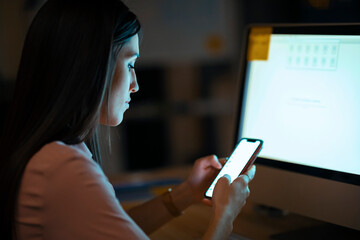 Young woman in office using smartphone