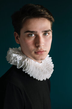 Handsome young man with ruff collar against wall at home