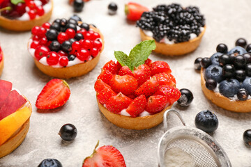 Tasty berry tartlets on grunge background
