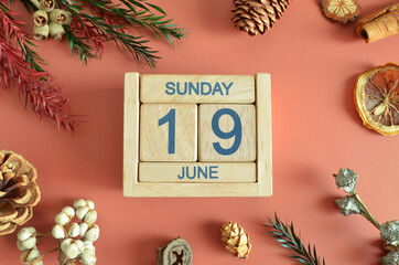 June 19, Cover design with calendar cube, pine cones and dried fruit in the natural concept.