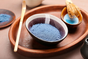 Tray with powdered blue matcha tea on color background, closeup