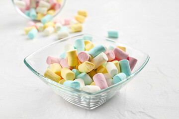 Bowl with tasty colorful marshmallows on light background, closeup