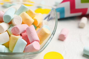 Bowl with tasty colorful marshmallows on light background, closeup