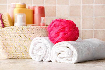 Obraz na płótnie Canvas Clean towels, bath sponge and cosmetics on table, closeup