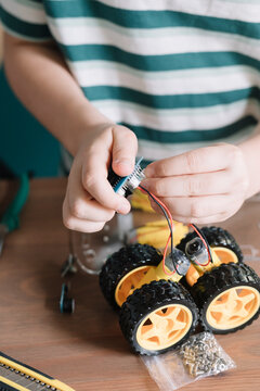 Close-up of boy making robotic toy on table at home