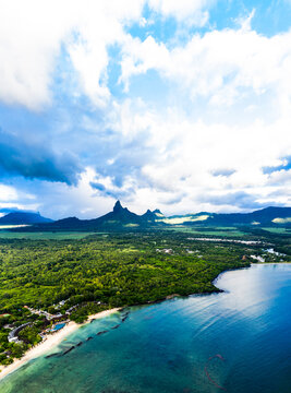 Mauritius, Black River, Flic-en-Flac, Helicopter view of clouds over oceanside village in summer with Trois Mamelles range in background