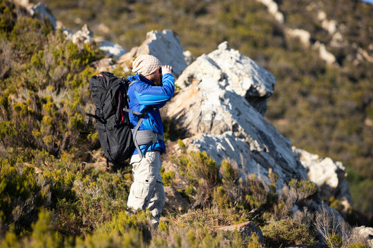Spain, Andalusia, Tarifa, man on a hiking trip in the mountains looking through binocular