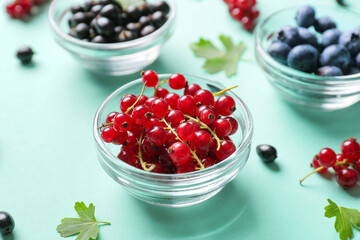 Bowls with different ripe berries on color background, closeup