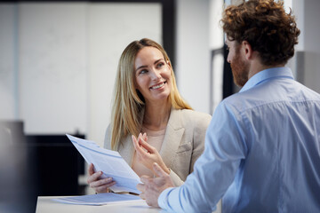 Businessman and businesswoman working together on papers in office