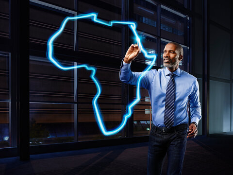 Businessman painting Africa with light