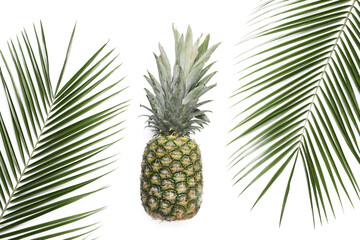 Ripe pineapple and palm leaves on white background