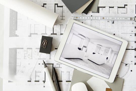 ArchitecturalÔøΩblueprints and digital tablet displaying modern showcase interior