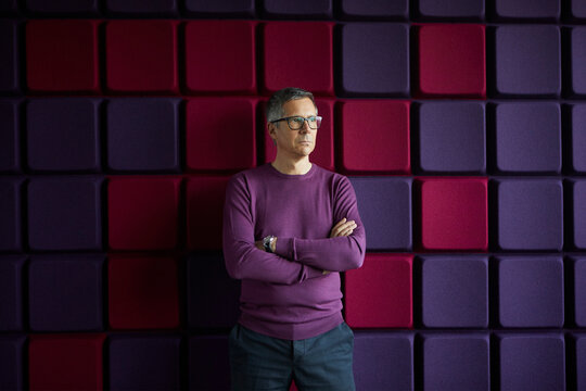 Businessman standing at a noise reduction wall in office
