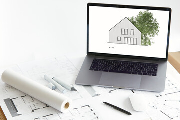 Architecture model of home ownership with tree on screen of laptop, construction plan