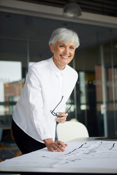 Portrait of smiling architect working on construction plan in office