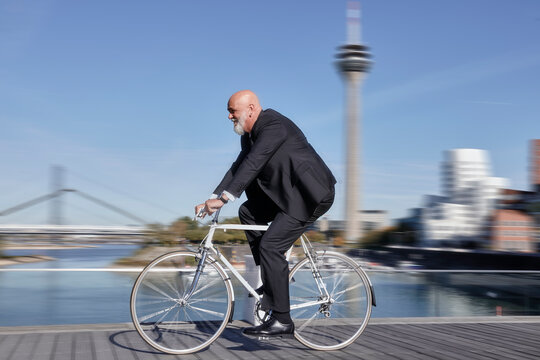 Elegant businessman riding racing bike