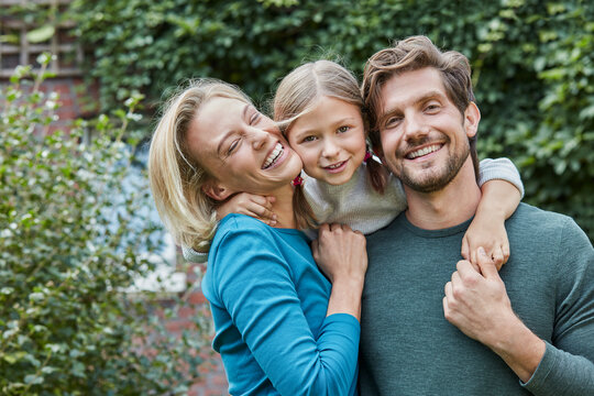 Portrait of happy family in garden of their home