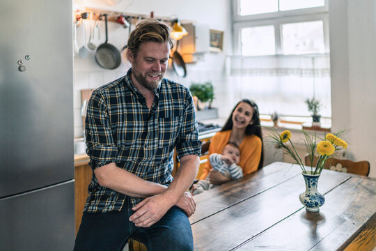Smiling man with family in kitchen at home